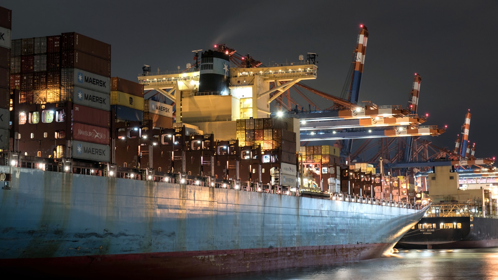 A large cargo ship in a harbor at night